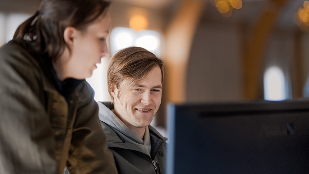 Man and woman in front of computer screen